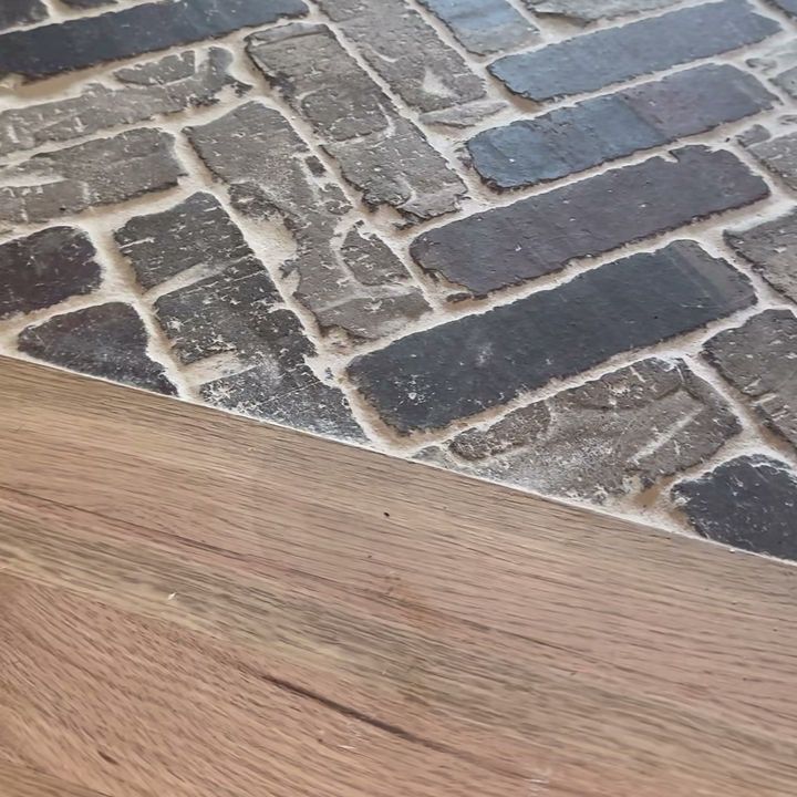 Herringbone brick floor meeting a wood floor in a doorway.