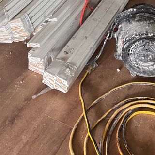 Bundles of baseboard and trim stock on a new plank floor.