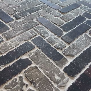 A finished rustic brick floor in a herringbone pattern, grouted.