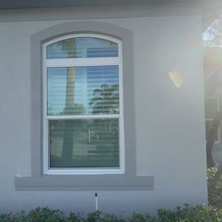 Fresh gray paint around an arched window.