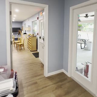 A plank floor running through a doorway with white casings.