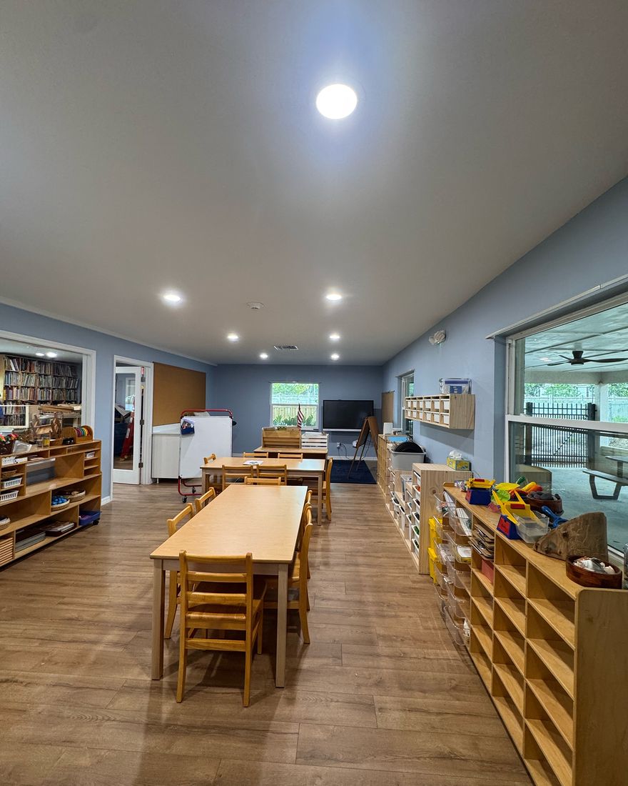 A long room with blue-gray painted walls, white baseboards and a new floor.