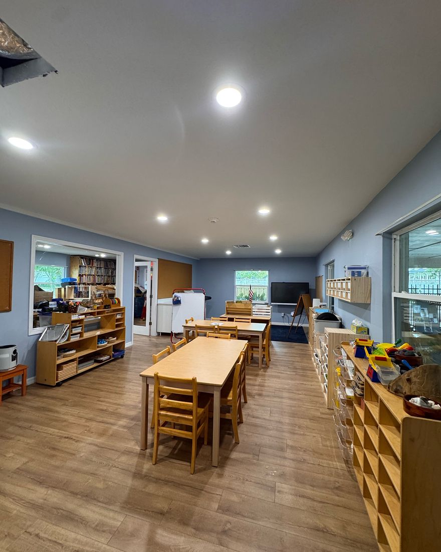 A long room with smooth blue-gray walls and white baseboards.