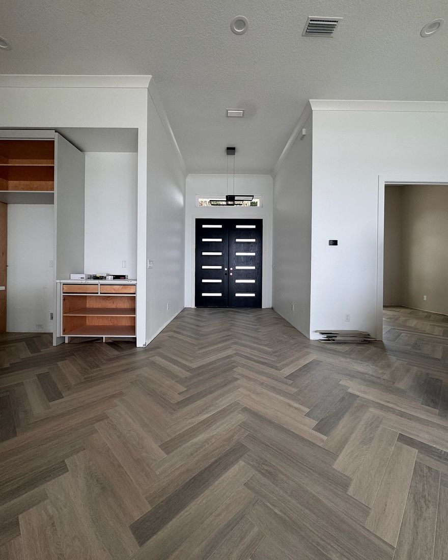 An entry hall with a gray herringbone floor.