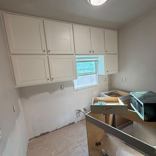 New white kitchen cabinets going in over a protected floor.