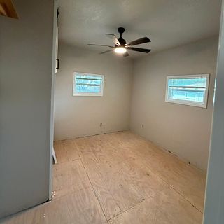 A bedroom with new subfloor sheets down.