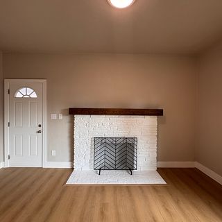 Fresh walls around a white brick fireplace.