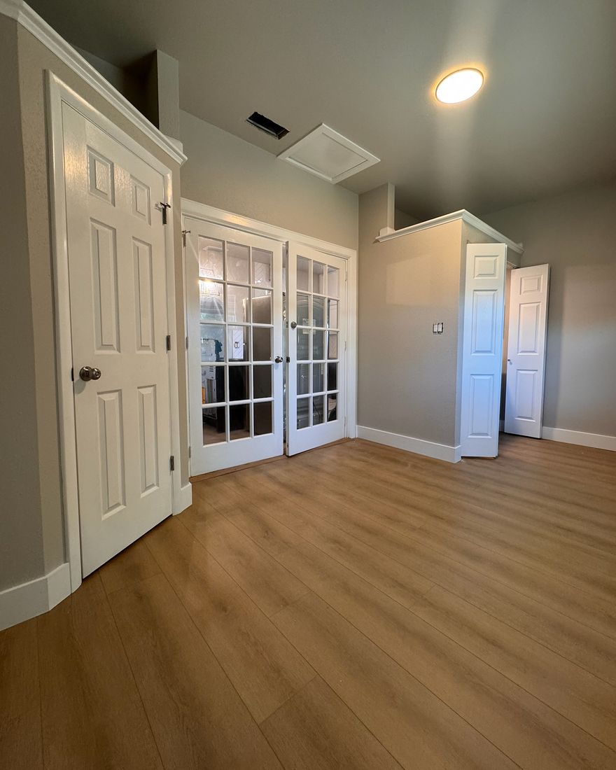 A study with a glass-paneled entry and a new wood-look plank floor.