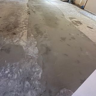 A concrete slab with strips of leveling compound filling the low spots.
