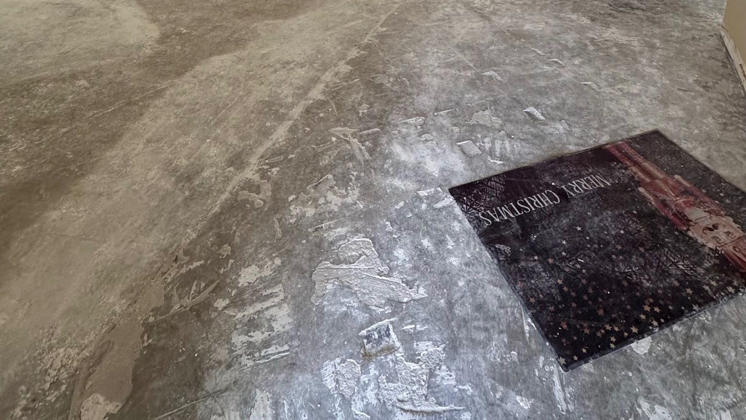 An open room with the old floor removed and the concrete slab scraped.
