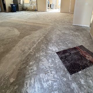A concrete slab scraped clean after the old tile came out.